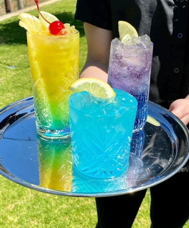 Colourful cocktails served on a tray outdoors