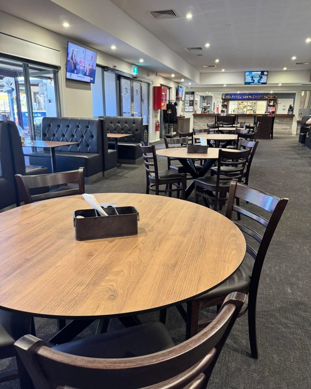 Indoor club dining area with tables, chairs, and bar